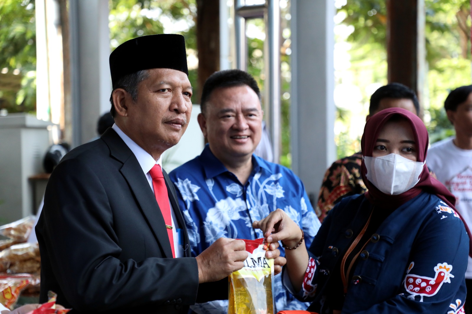 Kepala Biro Keuangan selaku Ketua Panitia Bazar Ramadan Tavip Joko Prahoro (Kiri) menyerahkan minyak kepada salahsatu pembeli dalam acara bazar Ramadan yang digelar di Graha BNPB, Jakarta, Selasa (21/3). 